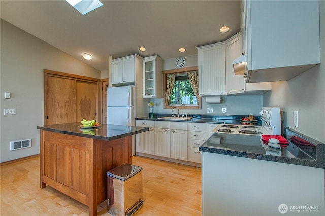 kitchen with a sink, visible vents, recessed lighting, light wood-style floors, and white appliances