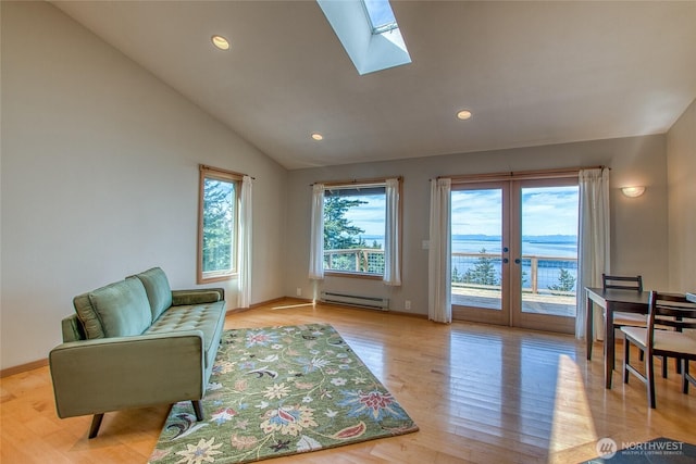 sitting room with recessed lighting, light wood-style floors, lofted ceiling with skylight, baseboards, and a baseboard radiator