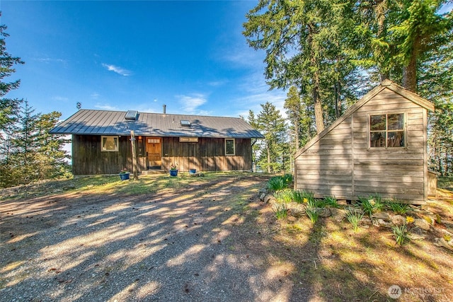 back of property featuring an outdoor structure and a shed