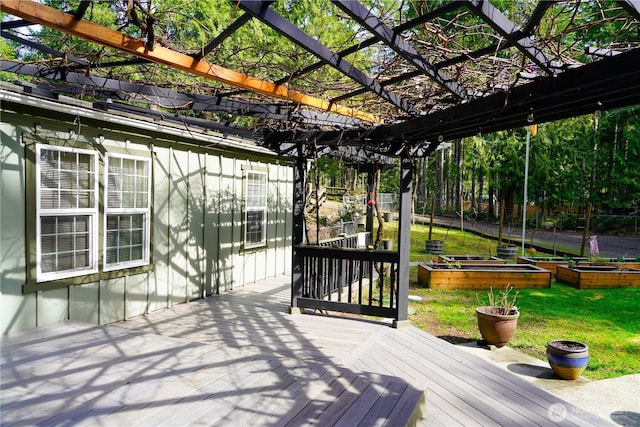 wooden deck featuring a vegetable garden, a pergola, and a yard