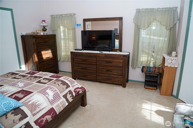 bedroom featuring baseboards and light carpet