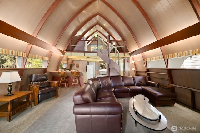 carpeted living area featuring stairs and lofted ceiling
