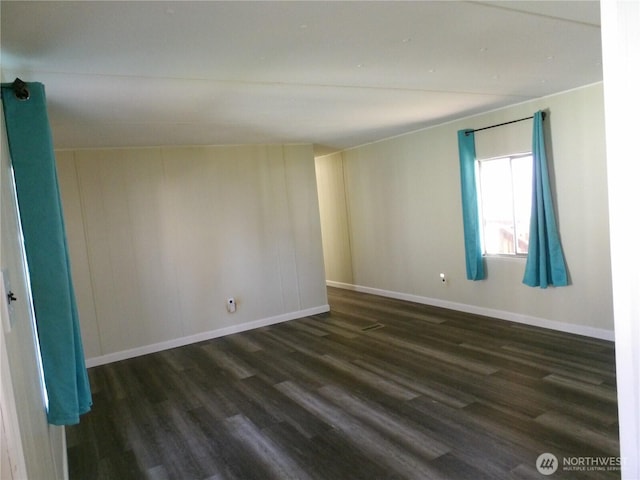 empty room with baseboards and dark wood finished floors
