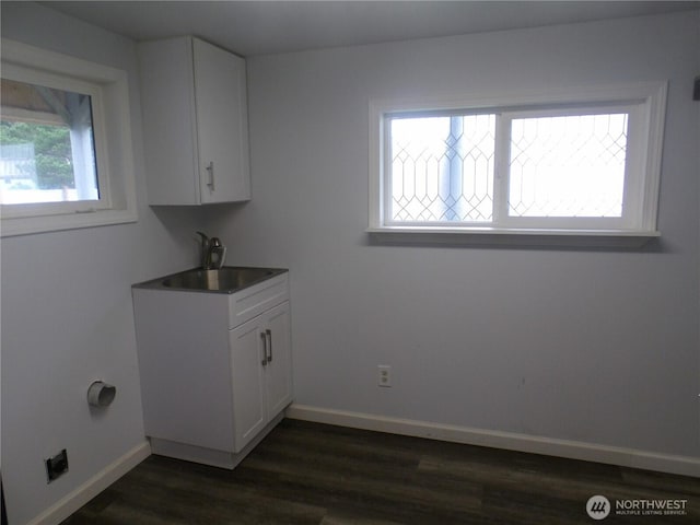 clothes washing area with a sink, dark wood-style floors, baseboards, and laundry area