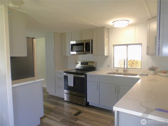 1308 263rd Pl, Ocean Park, WA 98640 - kitchen with appliances with stainless steel finishes, dark wood-type flooring, and light stone countertops