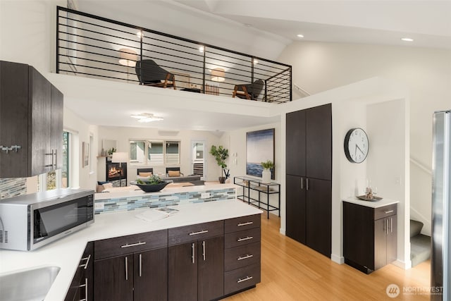 3924 S Brandon St Unit A, Seattle, WA 98118 - kitchen featuring high vaulted ceiling, a peninsula, stainless steel appliances, and light countertops