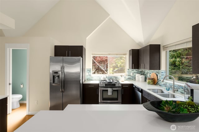 3924 S Brandon St Unit A, Seattle, WA 98118 - kitchen with stainless steel appliances, a sink, a healthy amount of sunlight, tasteful backsplash, and light countertops