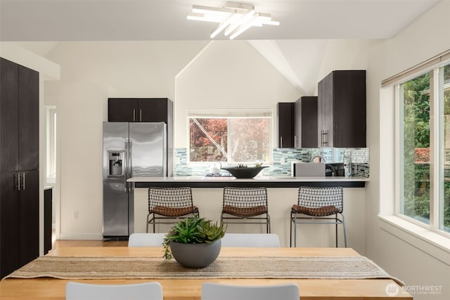 3924 S Brandon St Unit A, Seattle, WA 98118 - kitchen featuring a kitchen bar, decorative backsplash, stainless steel refrigerator with ice dispenser, and a wealth of natural light