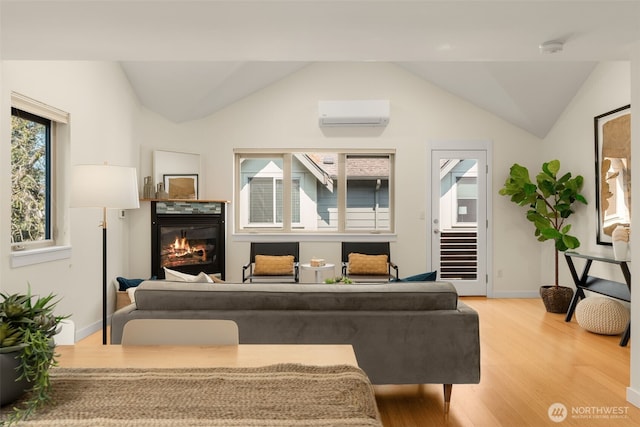 3924 S Brandon St Unit A, Seattle, WA 98118 - living room with a wall mounted air conditioner, wood finished floors, a glass covered fireplace, baseboards, and lofted ceiling