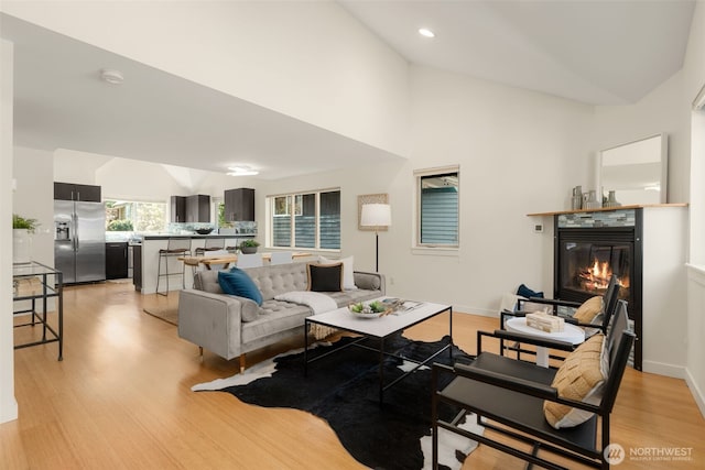 3924 S Brandon St Unit A, Seattle, WA 98118 - living room featuring a glass covered fireplace, light wood-style floors, baseboards, lofted ceiling, and recessed lighting
