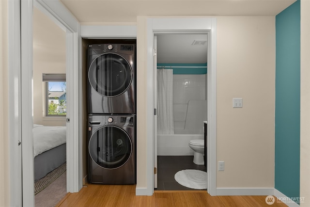 3924 S Brandon St Unit A, Seattle, WA 98118 - laundry area featuring wood finished floors, stacked washer and dryer, baseboards, and laundry area