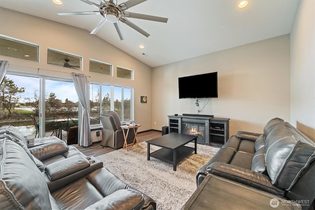 living room with ceiling fan, recessed lighting, a glass covered fireplace, and wood finished floors