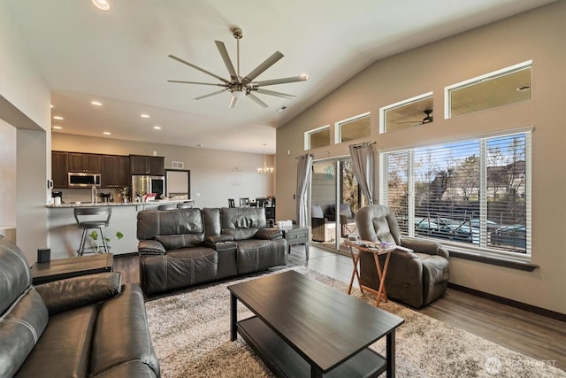 living room featuring recessed lighting, ceiling fan with notable chandelier, and a healthy amount of sunlight