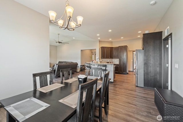 dining space featuring recessed lighting, visible vents, ceiling fan with notable chandelier, and wood finished floors