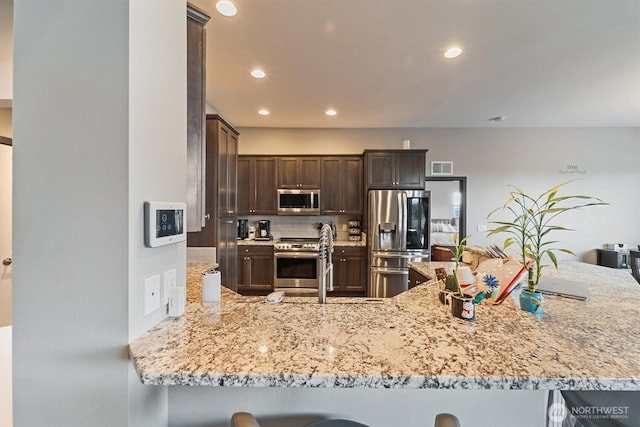kitchen featuring tasteful backsplash, dark brown cabinetry, recessed lighting, visible vents, and stainless steel appliances