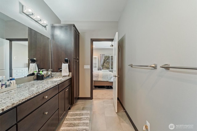 full bath with vanity, ensuite bath, a ceiling fan, tile patterned flooring, and baseboards