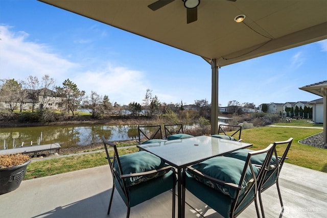 view of patio featuring outdoor dining space, a ceiling fan, and a water view