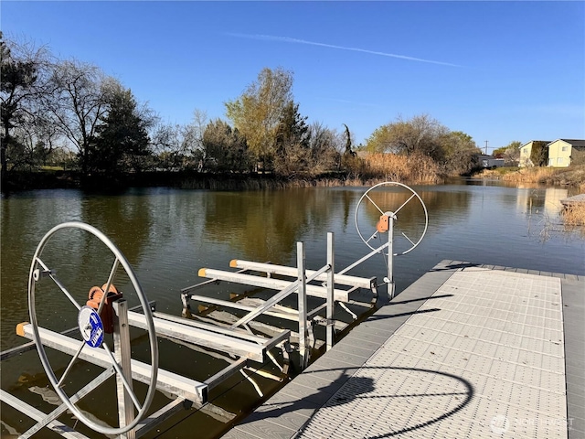 dock area with a water view and boat lift