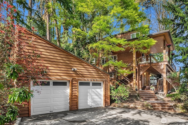 chalet / cabin with a garage, stairs, and driveway