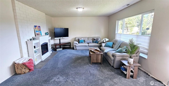 living room featuring dark colored carpet, a textured ceiling, and visible vents
