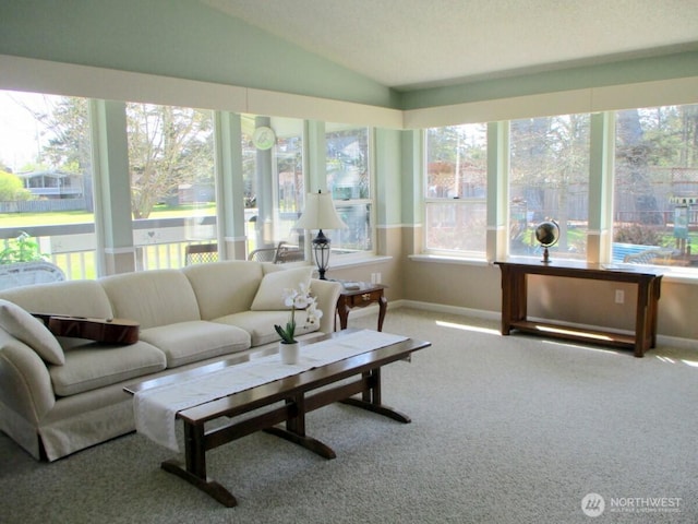 sunroom featuring baseboards, carpet flooring, and vaulted ceiling
