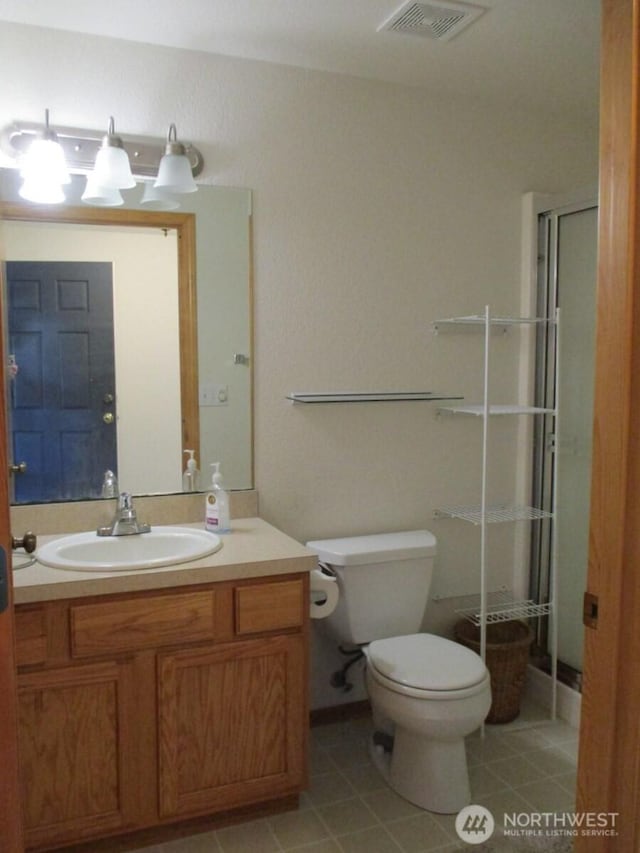 full bath with visible vents, tile patterned flooring, a shower stall, vanity, and toilet