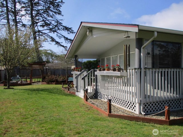 view of side of property with a lawn, fence, and a deck