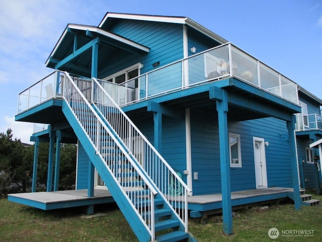 rear view of property featuring stairway and a deck