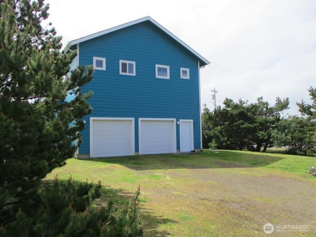 view of side of home featuring a yard and a garage