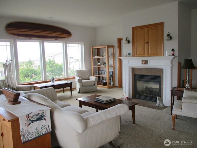 living area with a tiled fireplace and carpet