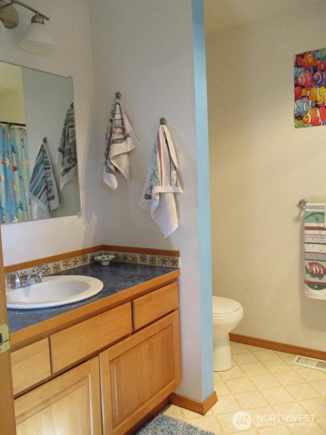 bathroom featuring visible vents, baseboards, toilet, tile patterned floors, and vanity