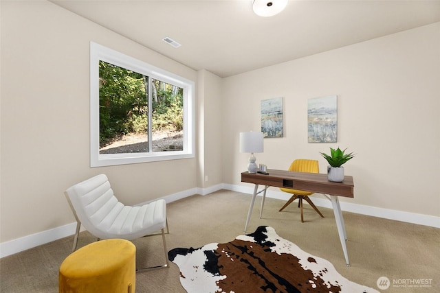 office space with baseboards, visible vents, and light carpet