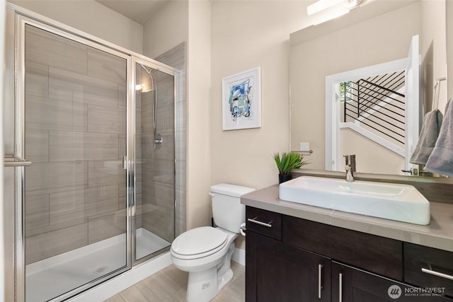 full bath with toilet, a shower stall, and vanity