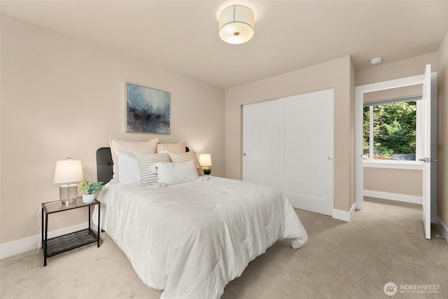 bedroom with baseboards, a closet, and light carpet