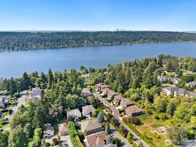 birds eye view of property with a water view, a residential view, and a wooded view