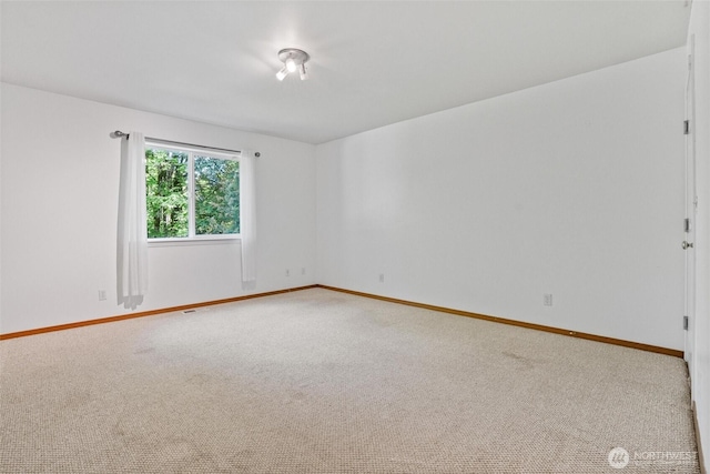 spare room with carpet floors and baseboards