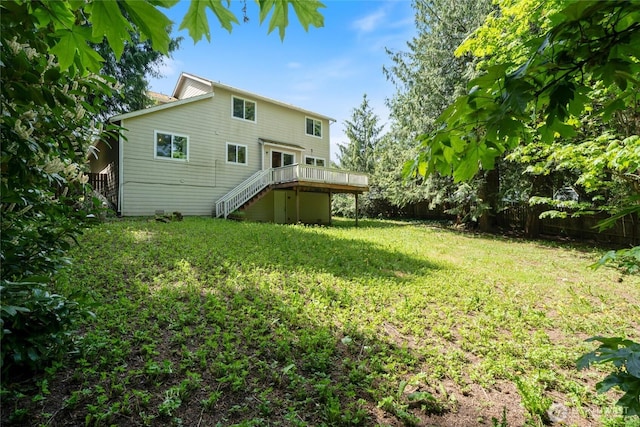 back of property with stairway, a deck, fence, and a lawn
