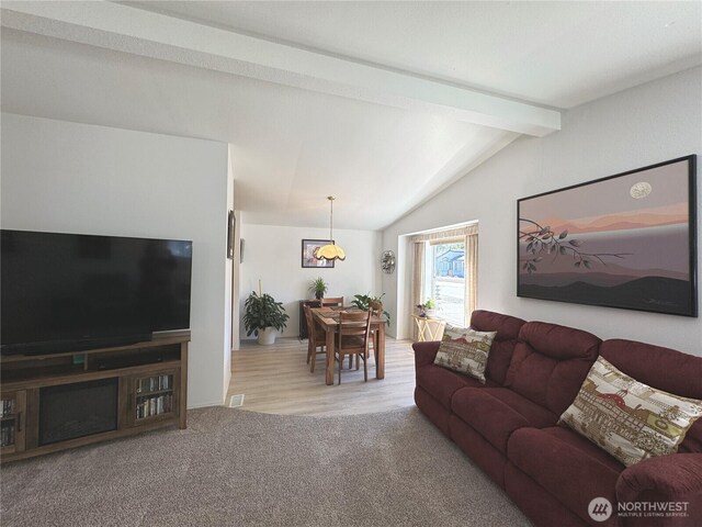 living room featuring vaulted ceiling with beams and carpet