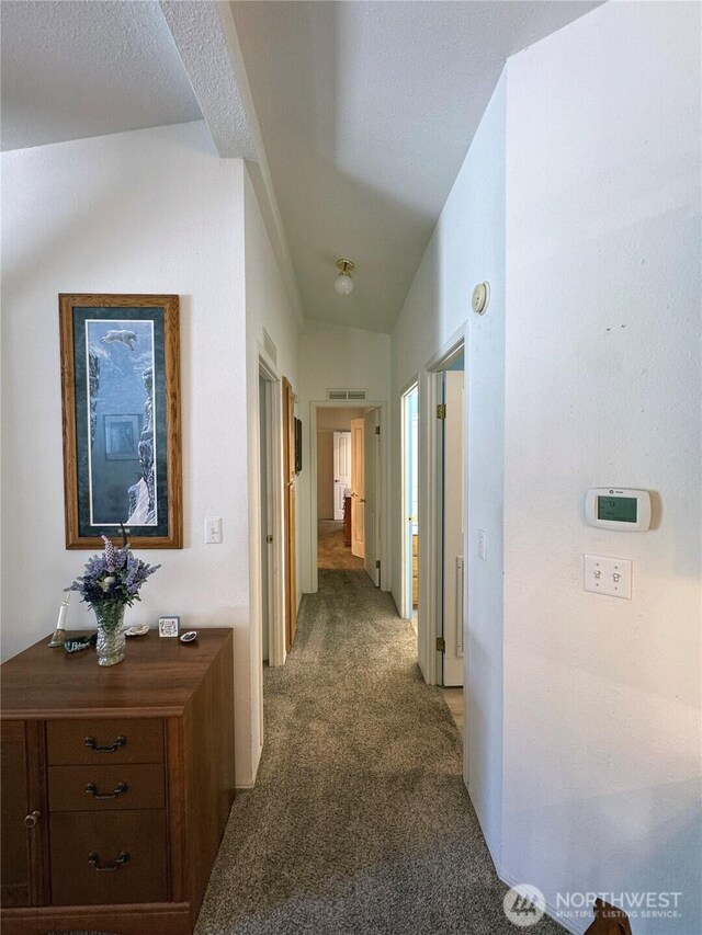 hallway with visible vents and light colored carpet