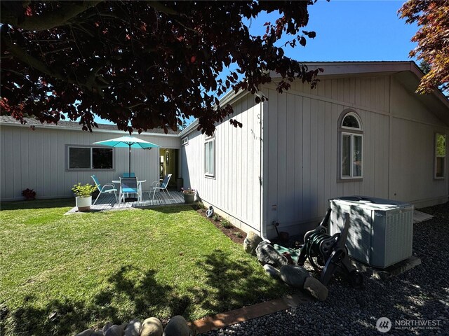 back of property featuring central AC unit and a yard