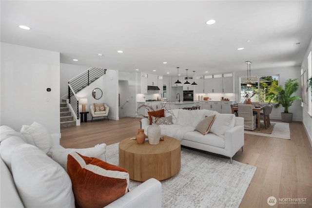 living area featuring stairway, recessed lighting, light wood-style flooring, and baseboards