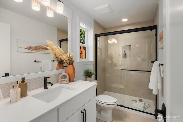 full bathroom featuring toilet, decorative backsplash, a stall shower, vanity, and recessed lighting