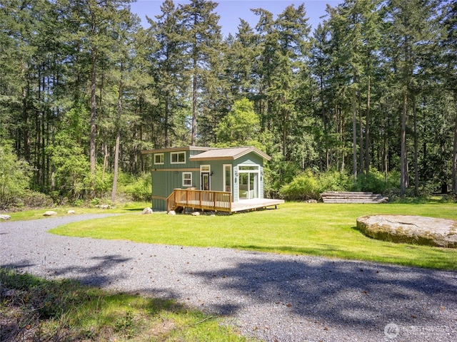 25 Eliza Ln, Lopez Island, WA 98261 - view of front of home featuring a wooded view, a front yard, and a deck