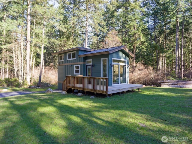 25 Eliza Ln, Lopez Island, WA 98261 - view of front of property with a front lawn, a deck, board and batten siding, and a wooded view