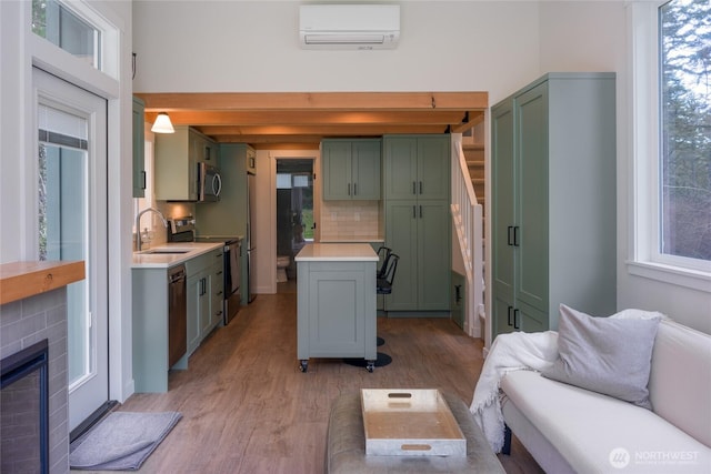 25 Eliza Ln, Lopez Island, WA 98261 - kitchen with a sink, green cabinets, appliances with stainless steel finishes, a wall mounted air conditioner, and a healthy amount of sunlight