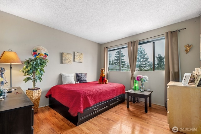 bedroom with light wood-style floors and a textured ceiling