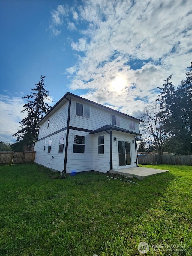 back of property featuring fence, a yard, and a patio area