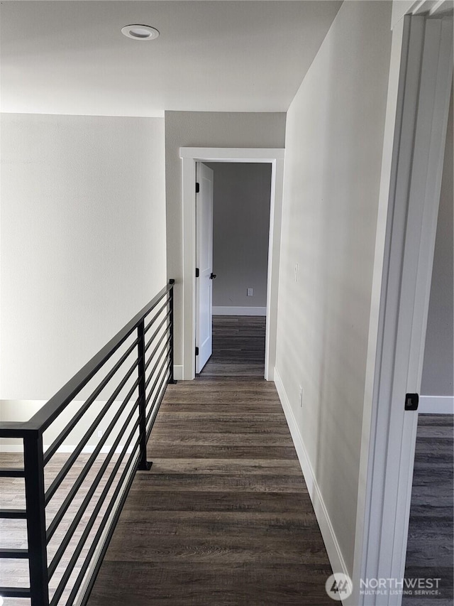 corridor featuring baseboards and wood finished floors