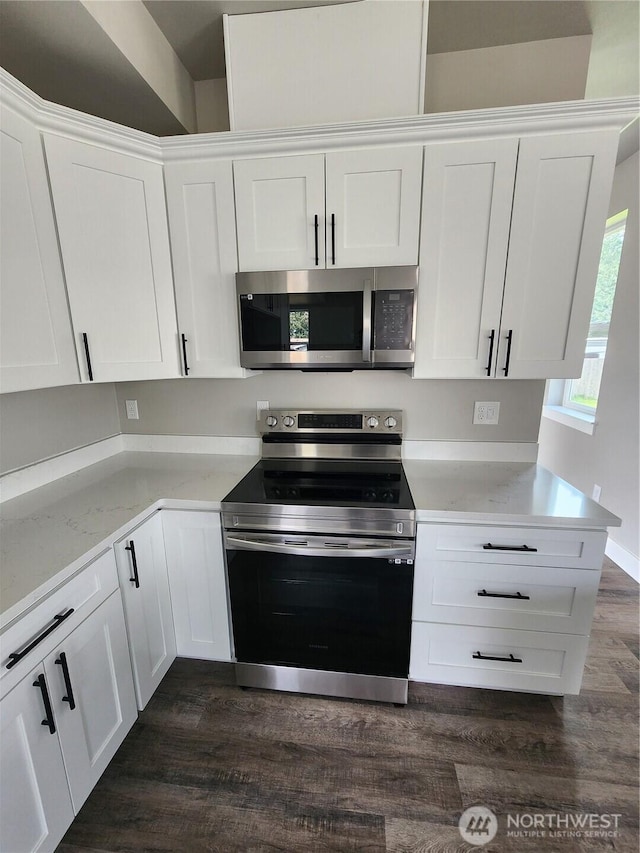 kitchen with white cabinetry, light stone countertops, appliances with stainless steel finishes, and dark wood finished floors