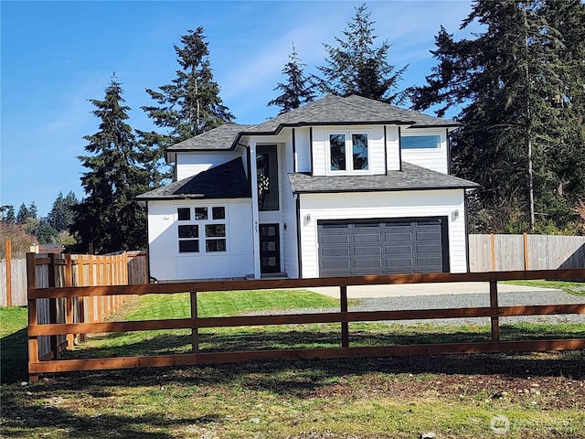view of front of house featuring a garage, driveway, a fenced front yard, and roof with shingles